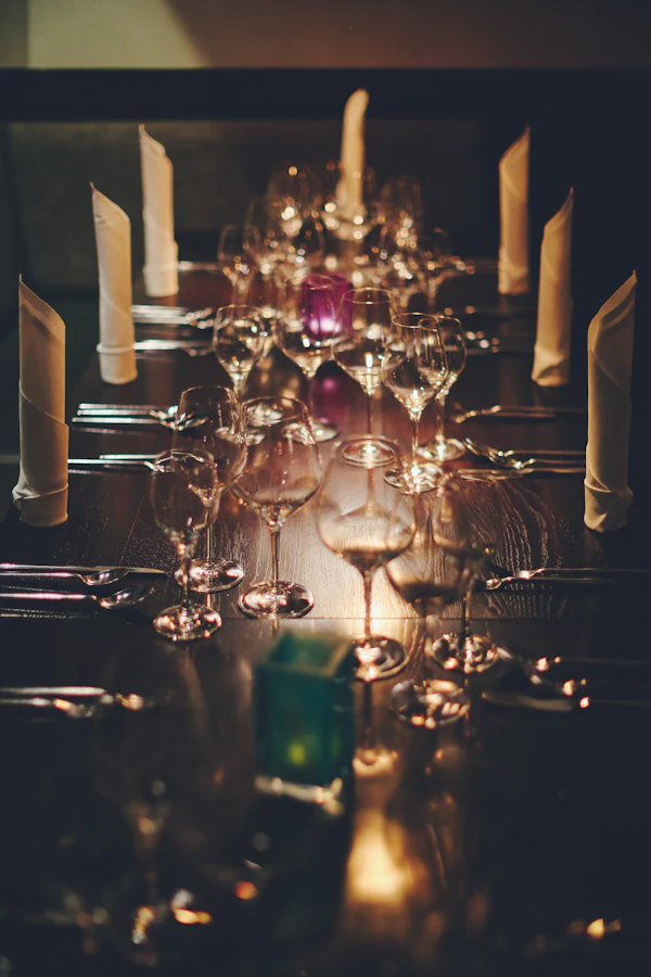 A softly lit dining table set with glasses and napkins