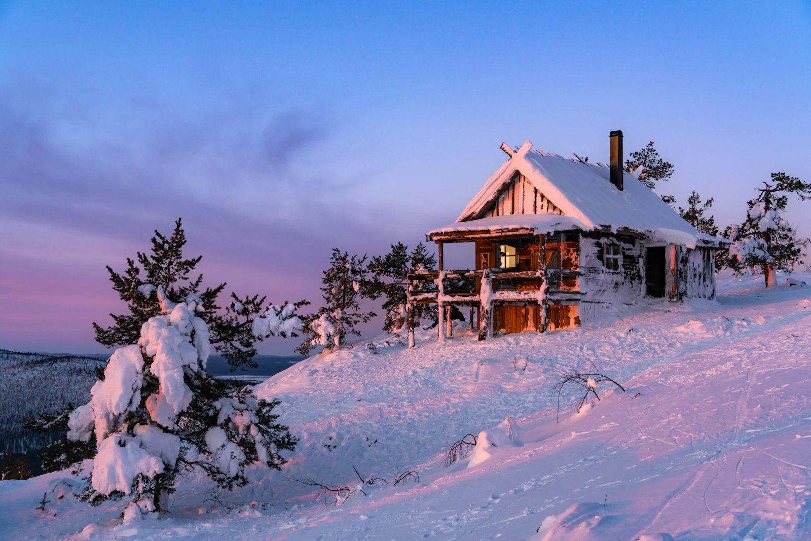 芬蘭列維雪地中的木屋與粉紫色冬日天空